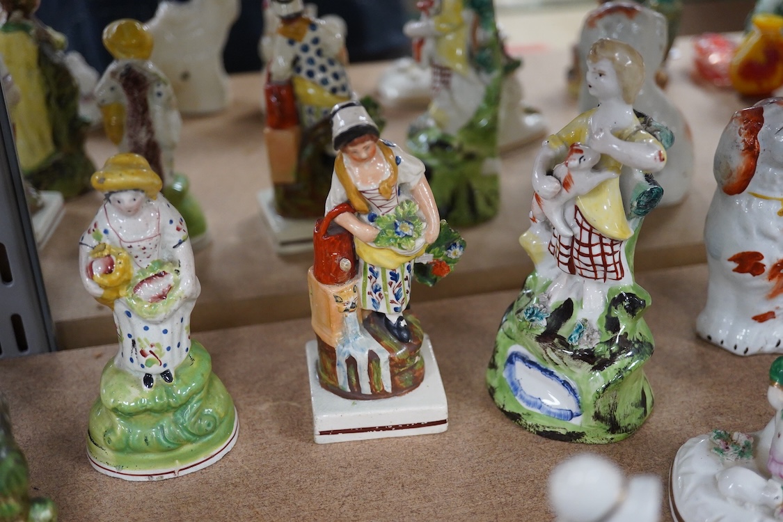 A collection of 19th century and later Staffordshire figures, mostly figural examples, including a pair a rare pair of porcelain seated figures with rabbits and a candle extinguisher, largest 15cm high (15)